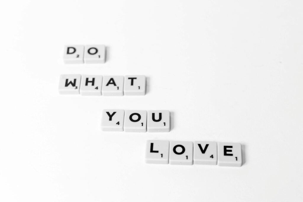 Scrabble tiles spelling 'Do What You Love' on a minimalist white background.